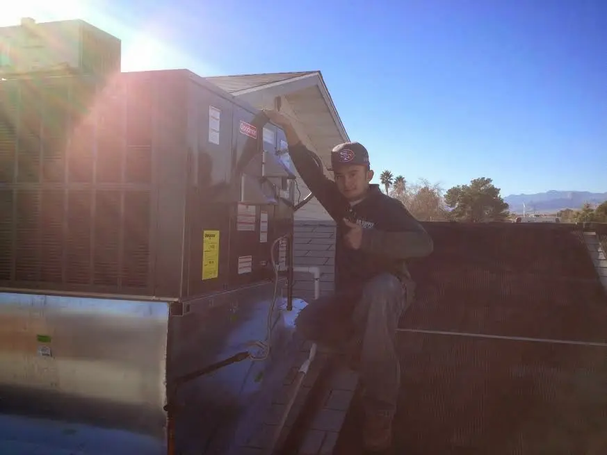 HVAC technician performing AC Tune-Up on a rooftop unit in Wahiawa